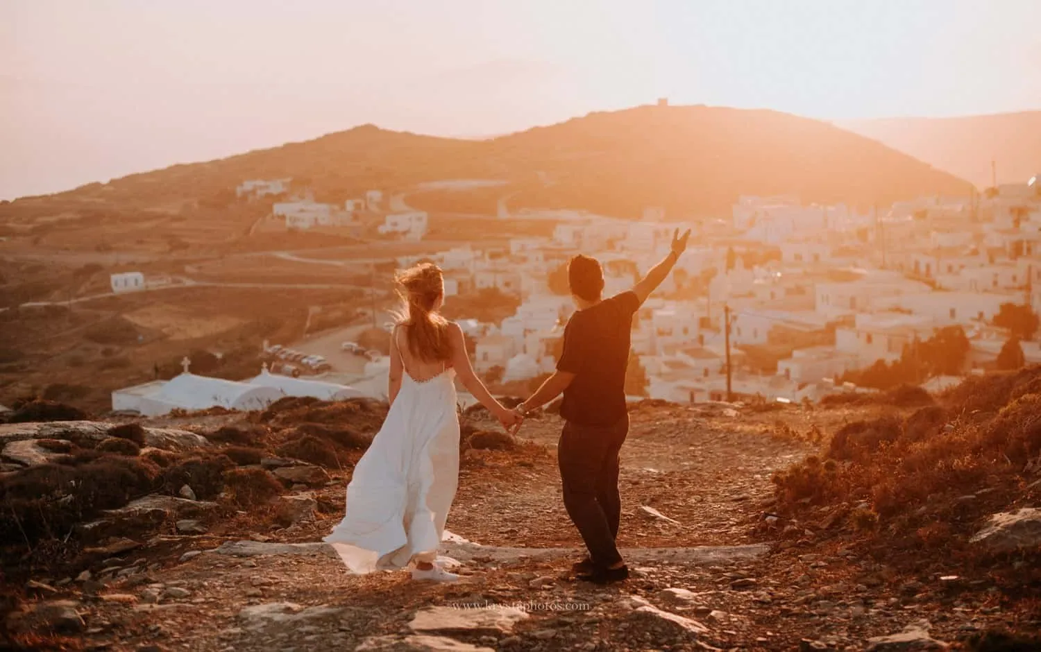 Couple holding hands at sunset overlooking Amorgos, Greece